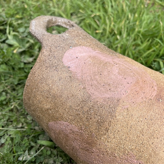 Clay pottery on grass with brushes marks on the crack clay. 